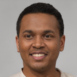 Joyful latino young-adult male with short  black hair and brown eyes