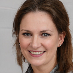 Joyful white adult female with medium  brown hair and grey eyes