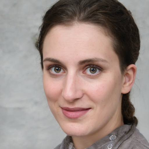 Joyful white young-adult female with medium  brown hair and grey eyes