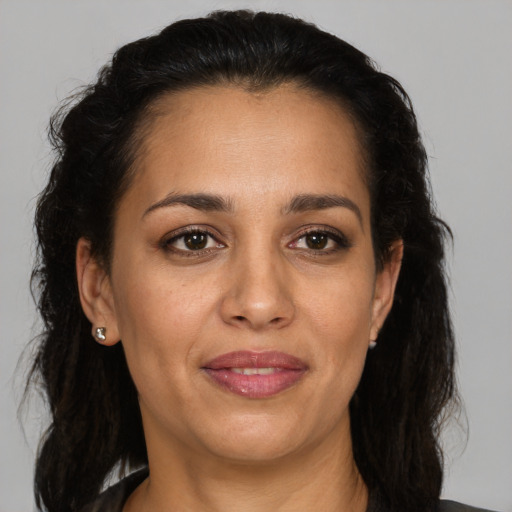 Joyful latino adult female with medium  brown hair and brown eyes