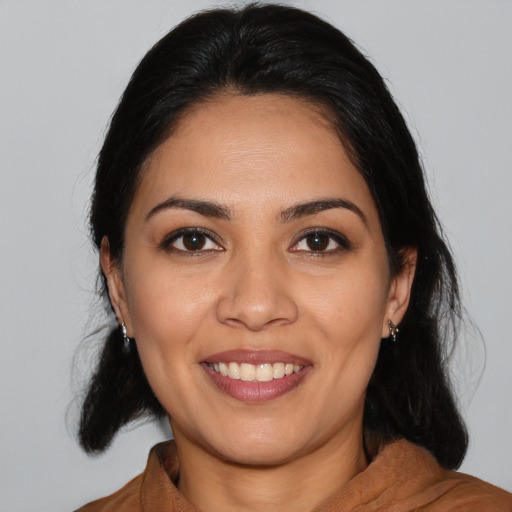 Joyful latino young-adult female with medium  black hair and brown eyes