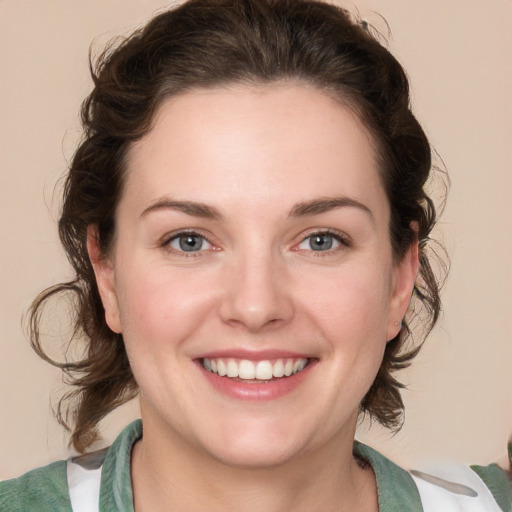 Joyful white young-adult female with medium  brown hair and green eyes