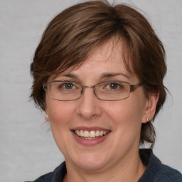 Joyful white adult female with medium  brown hair and blue eyes