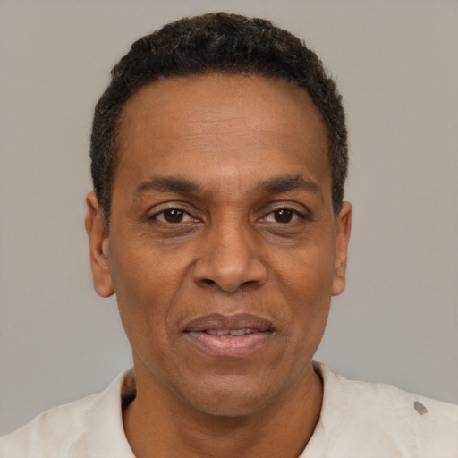 Joyful black adult male with short  black hair and brown eyes