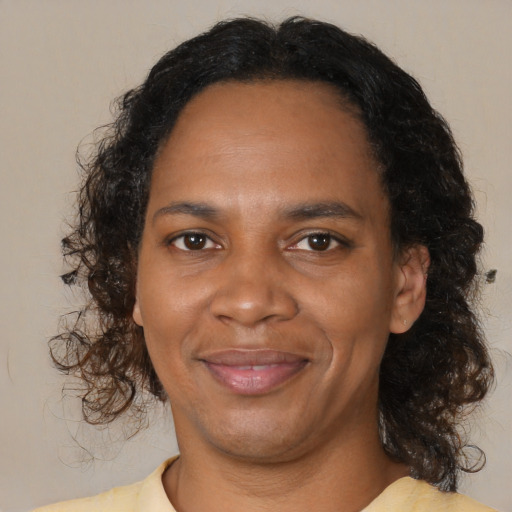 Joyful black adult female with medium  brown hair and brown eyes