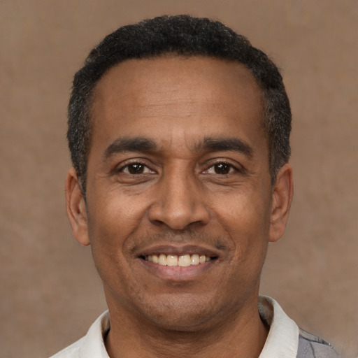 Joyful latino adult male with short  black hair and brown eyes