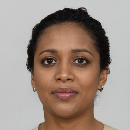 Joyful black young-adult female with short  black hair and brown eyes