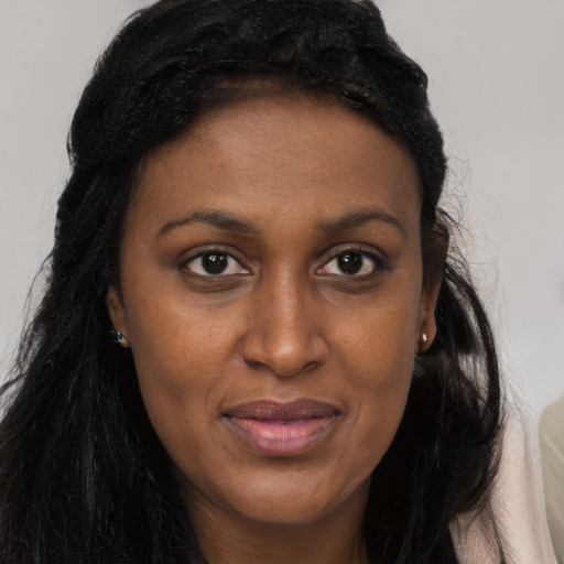 Joyful black young-adult female with long  brown hair and brown eyes