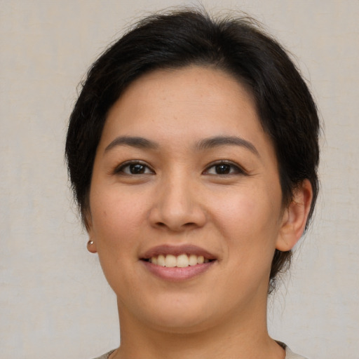Joyful latino young-adult female with short  brown hair and brown eyes