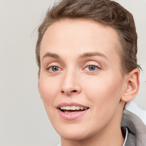 Joyful white young-adult female with short  brown hair and grey eyes