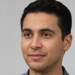 Joyful latino young-adult male with short  black hair and brown eyes