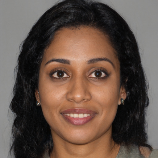 Joyful black young-adult female with long  black hair and brown eyes