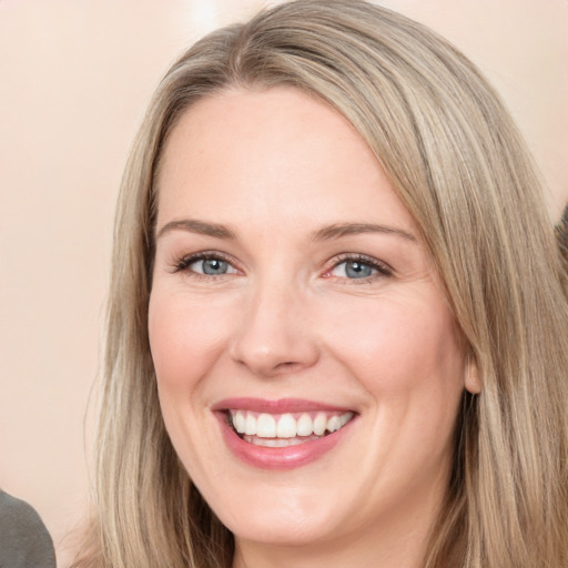 Joyful white adult female with long  brown hair and green eyes