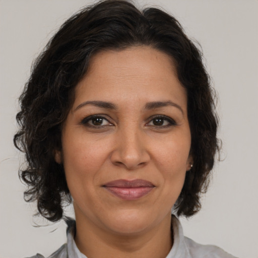 Joyful latino adult female with medium  brown hair and brown eyes