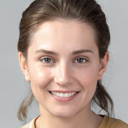 Joyful white young-adult female with medium  brown hair and grey eyes