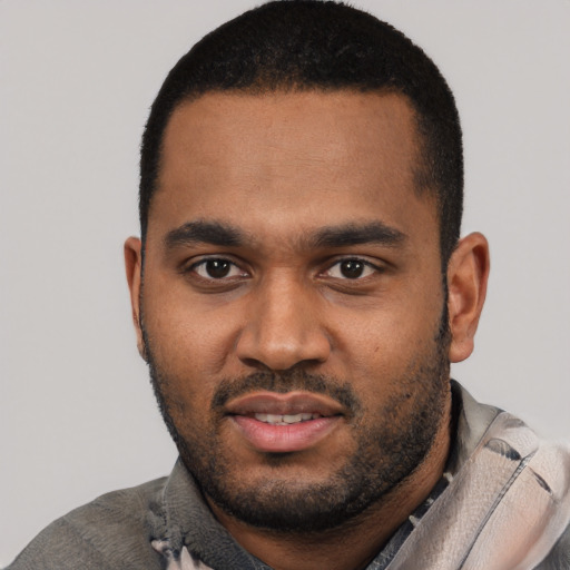 Joyful black young-adult male with short  black hair and brown eyes
