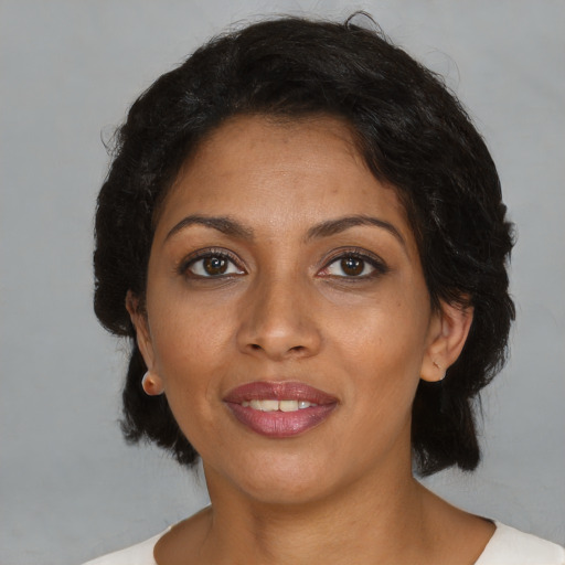 Joyful black adult female with medium  black hair and brown eyes