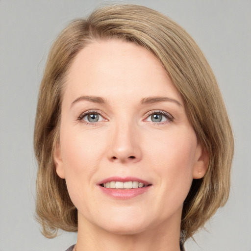 Joyful white adult female with medium  brown hair and green eyes