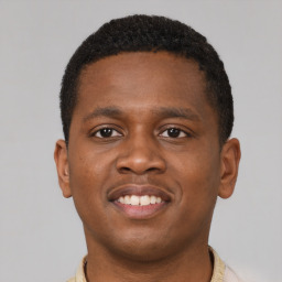 Joyful black young-adult male with short  brown hair and brown eyes