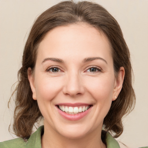 Joyful white young-adult female with medium  brown hair and green eyes