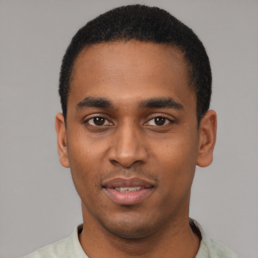 Joyful black young-adult male with short  black hair and brown eyes