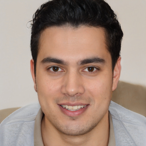 Joyful latino young-adult male with short  brown hair and brown eyes