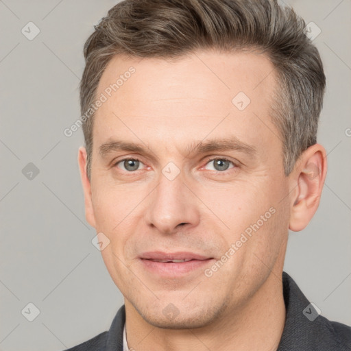 Joyful white adult male with short  brown hair and grey eyes