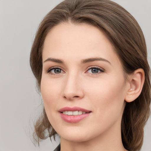 Joyful white young-adult female with medium  brown hair and grey eyes