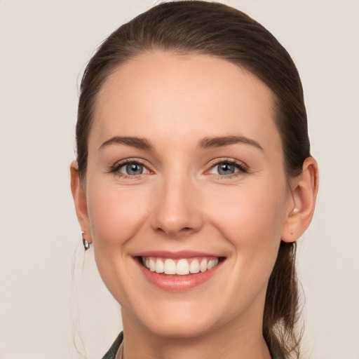 Joyful white young-adult female with long  brown hair and grey eyes