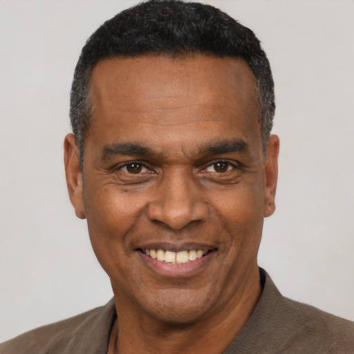 Joyful black adult male with short  black hair and brown eyes