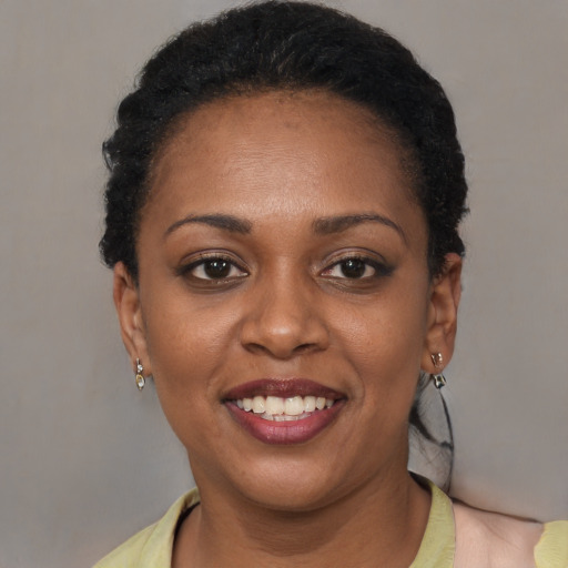 Joyful black adult female with short  brown hair and brown eyes