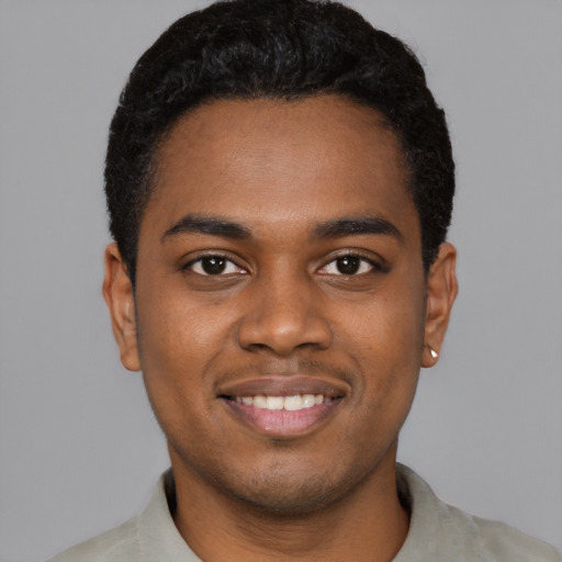 Joyful black young-adult male with short  black hair and brown eyes