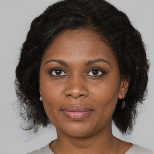 Joyful black young-adult female with medium  brown hair and brown eyes