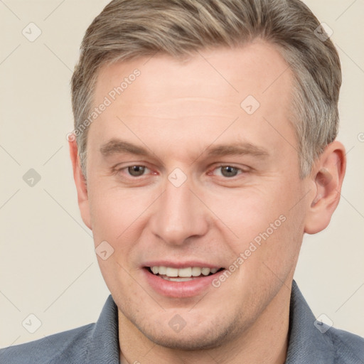 Joyful white adult male with short  brown hair and grey eyes