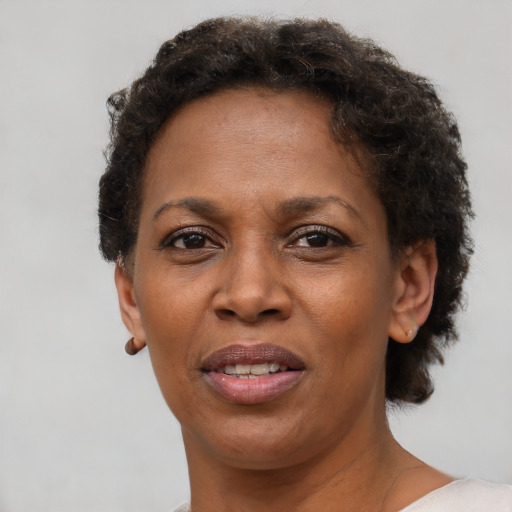 Joyful black adult female with short  brown hair and brown eyes