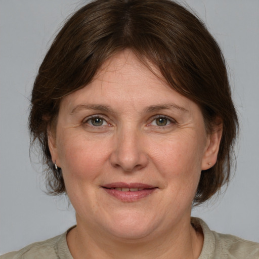 Joyful white adult female with medium  brown hair and grey eyes