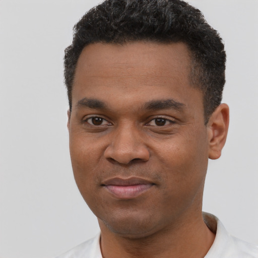 Joyful black young-adult male with short  black hair and brown eyes
