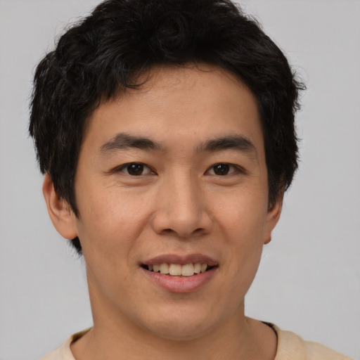 Joyful asian young-adult male with short  brown hair and brown eyes