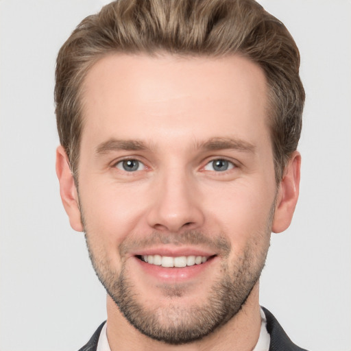 Joyful white young-adult male with short  brown hair and grey eyes