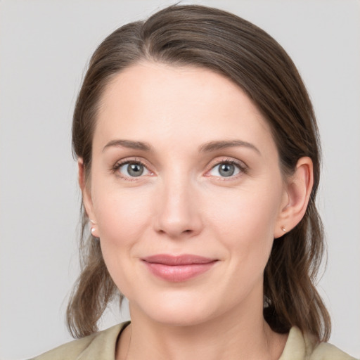 Joyful white young-adult female with medium  brown hair and grey eyes