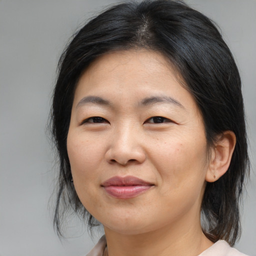 Joyful asian adult female with medium  brown hair and brown eyes