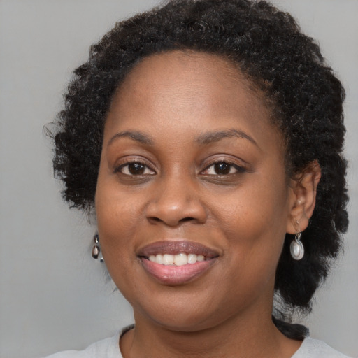 Joyful black young-adult female with medium  brown hair and brown eyes