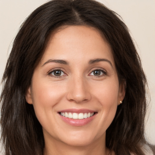 Joyful white young-adult female with long  brown hair and brown eyes