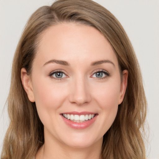 Joyful white young-adult female with long  brown hair and blue eyes