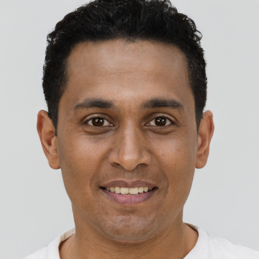 Joyful black young-adult male with short  brown hair and brown eyes