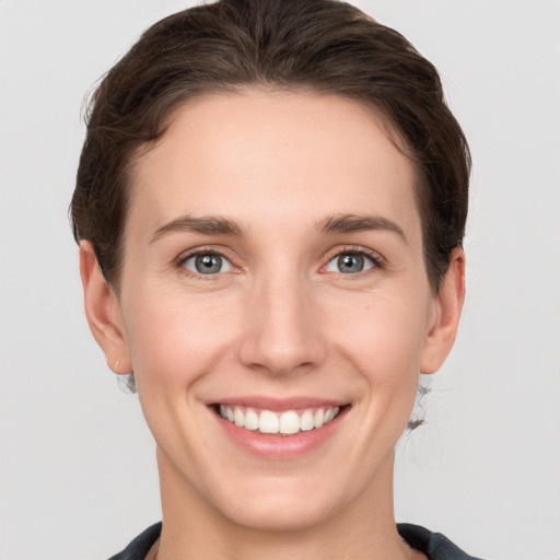 Joyful white young-adult female with short  brown hair and grey eyes