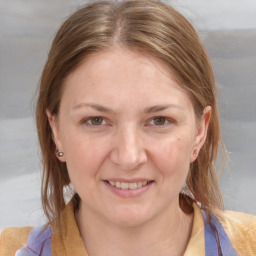 Joyful white young-adult female with medium  brown hair and blue eyes