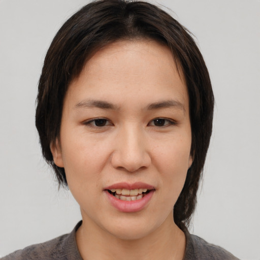 Joyful asian young-adult female with medium  brown hair and brown eyes