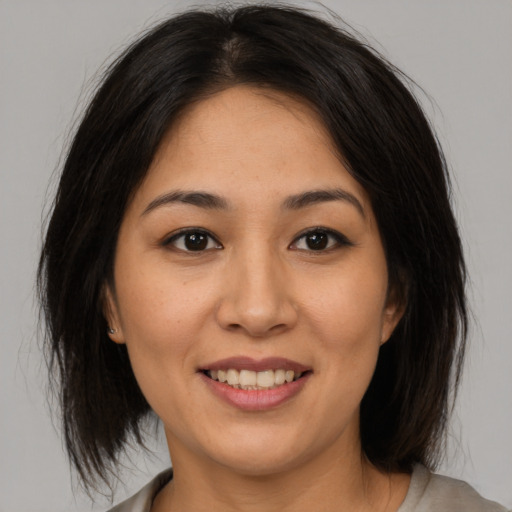 Joyful asian young-adult female with medium  brown hair and brown eyes