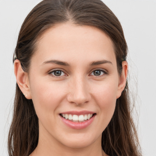 Joyful white young-adult female with long  brown hair and grey eyes